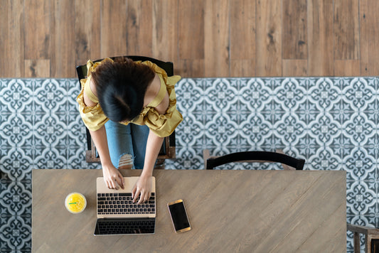 Top View of Young Woman Shopping Online in Modern Room with Mosaic and Wood-Look Tile Floor