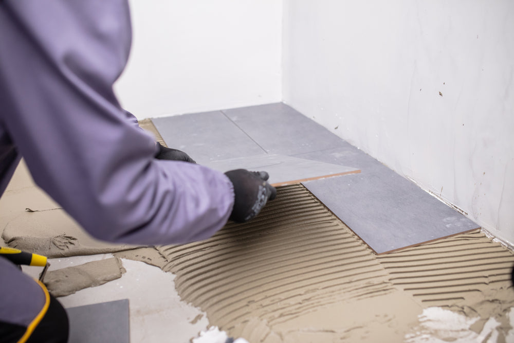 worker laying floor tile